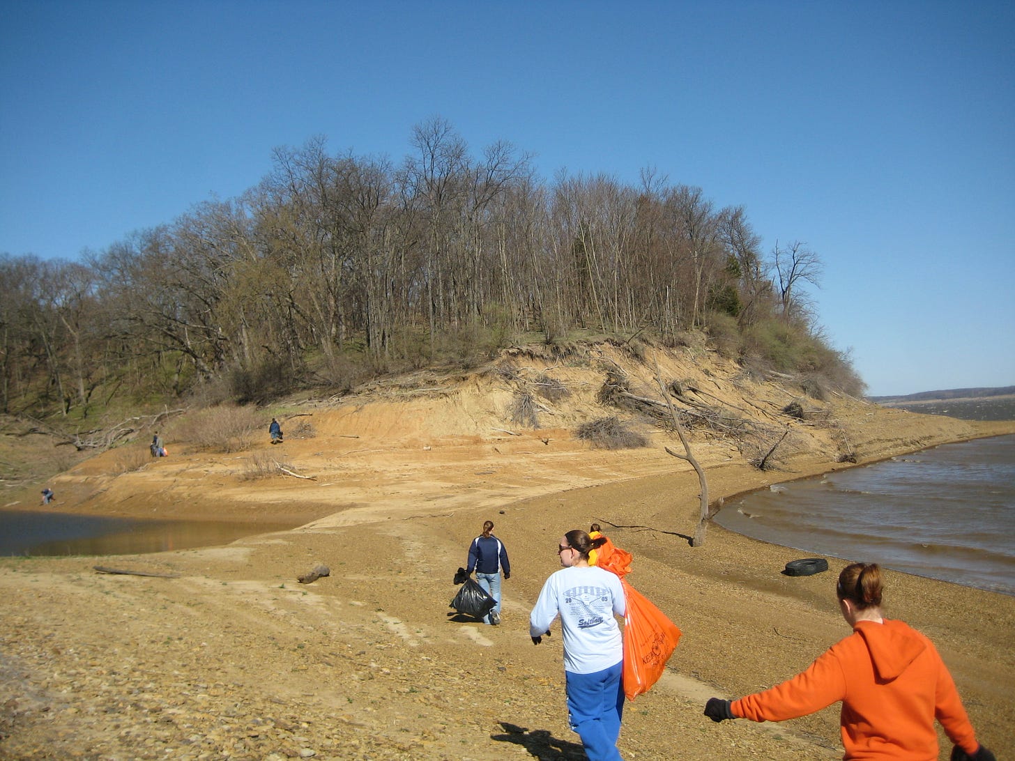 students gathering trash along a reservoir