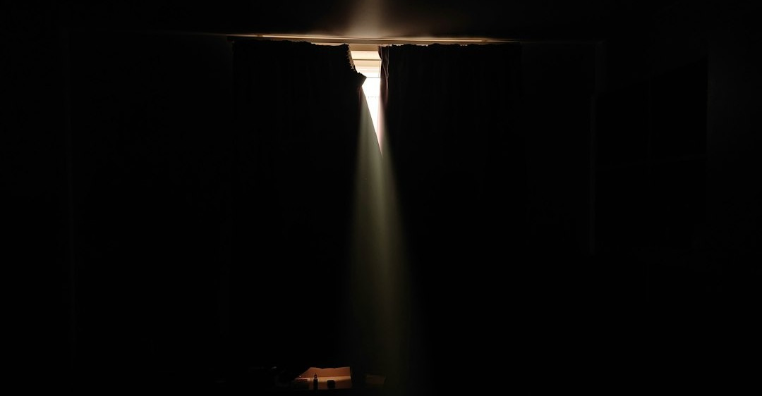 a dark room with a light coming from the ceiling
