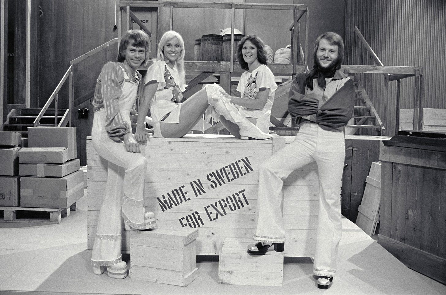 A black-and-white photo of the band ABBA in front of a wooden box with the writing *Made in Sweden for export*.