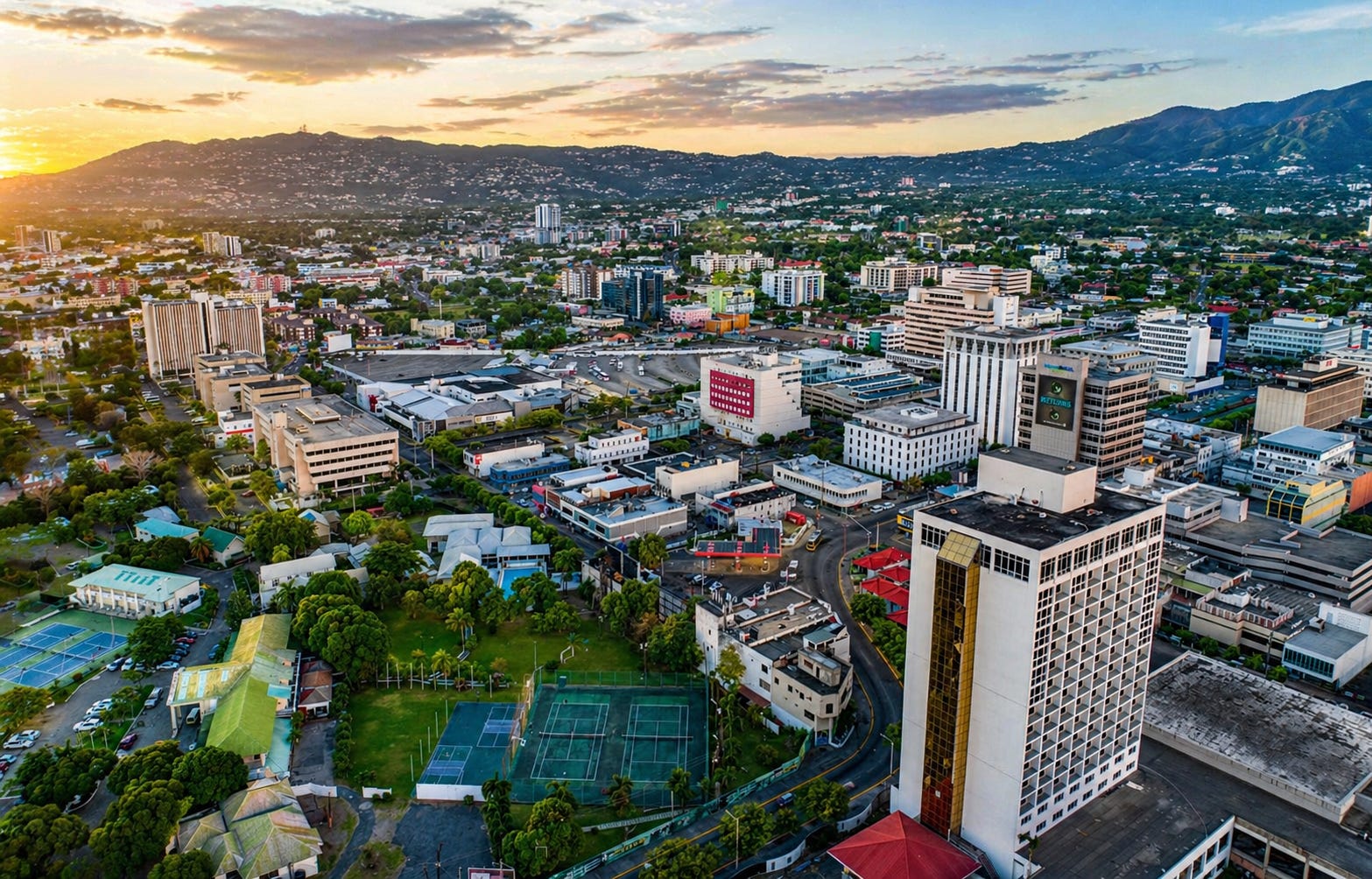 Aerial view of Kingston’s commercial core at dusk, where modern financial infrastructure is expanding against a backdrop of long-standing urban systems, highlighting the tension between digital ambition and real-world adoption in Jamaica’s economy.