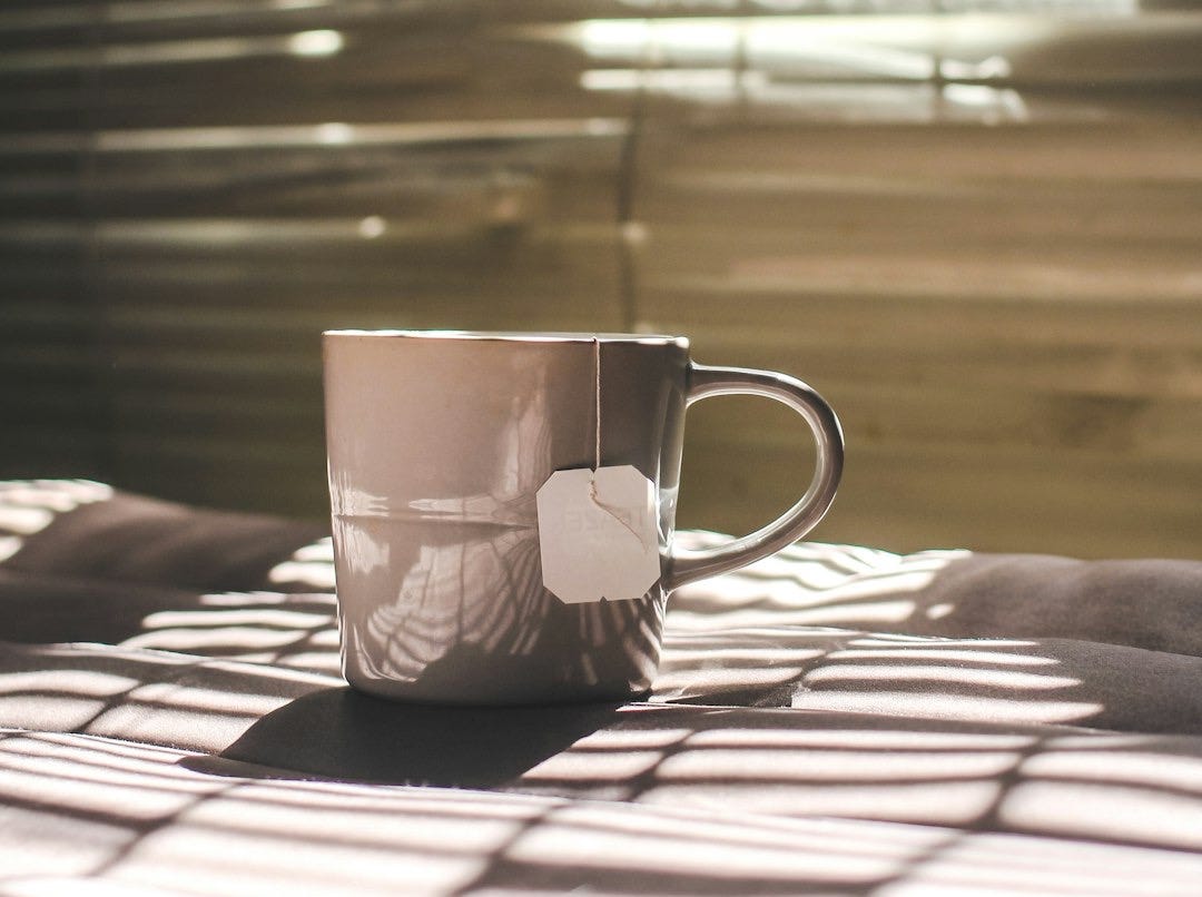 white and red ceramic mug on brown wooden table