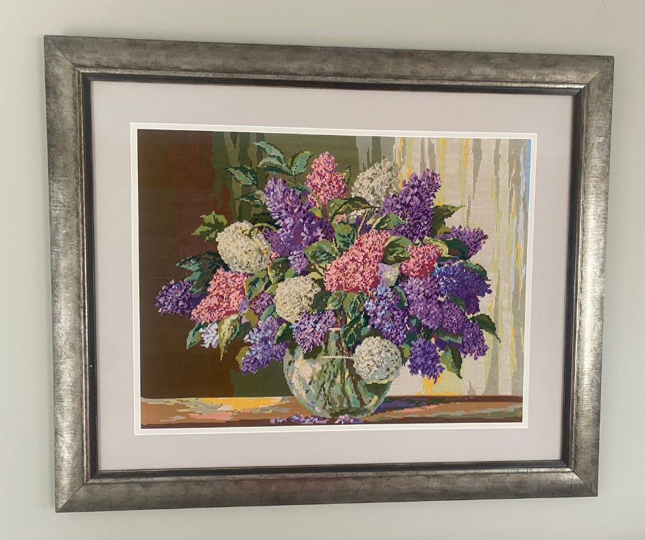 Silver framed photo of needlework of lilacs in vase