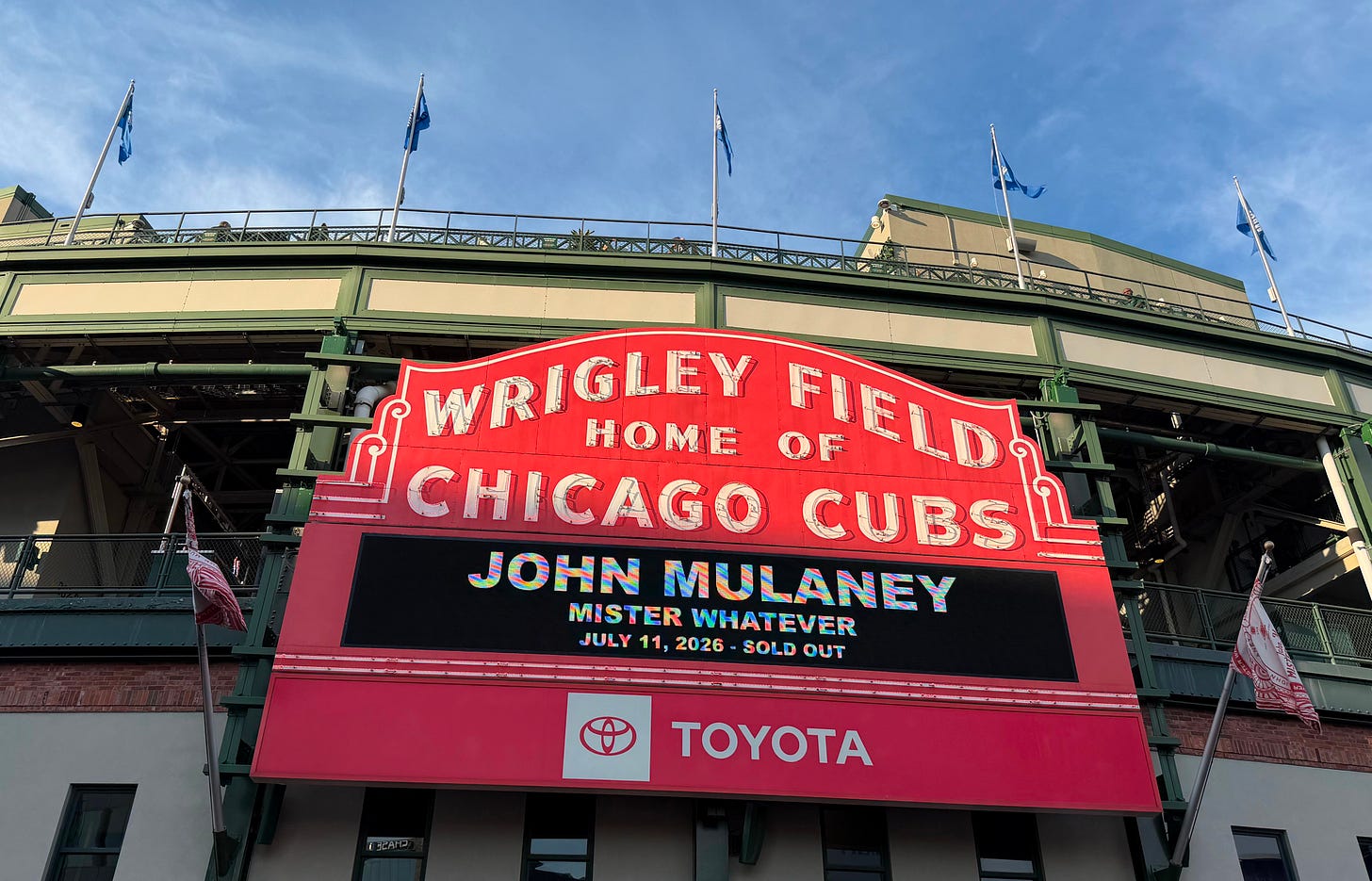 Wrigley Field sign with John Mulaney tour information on it