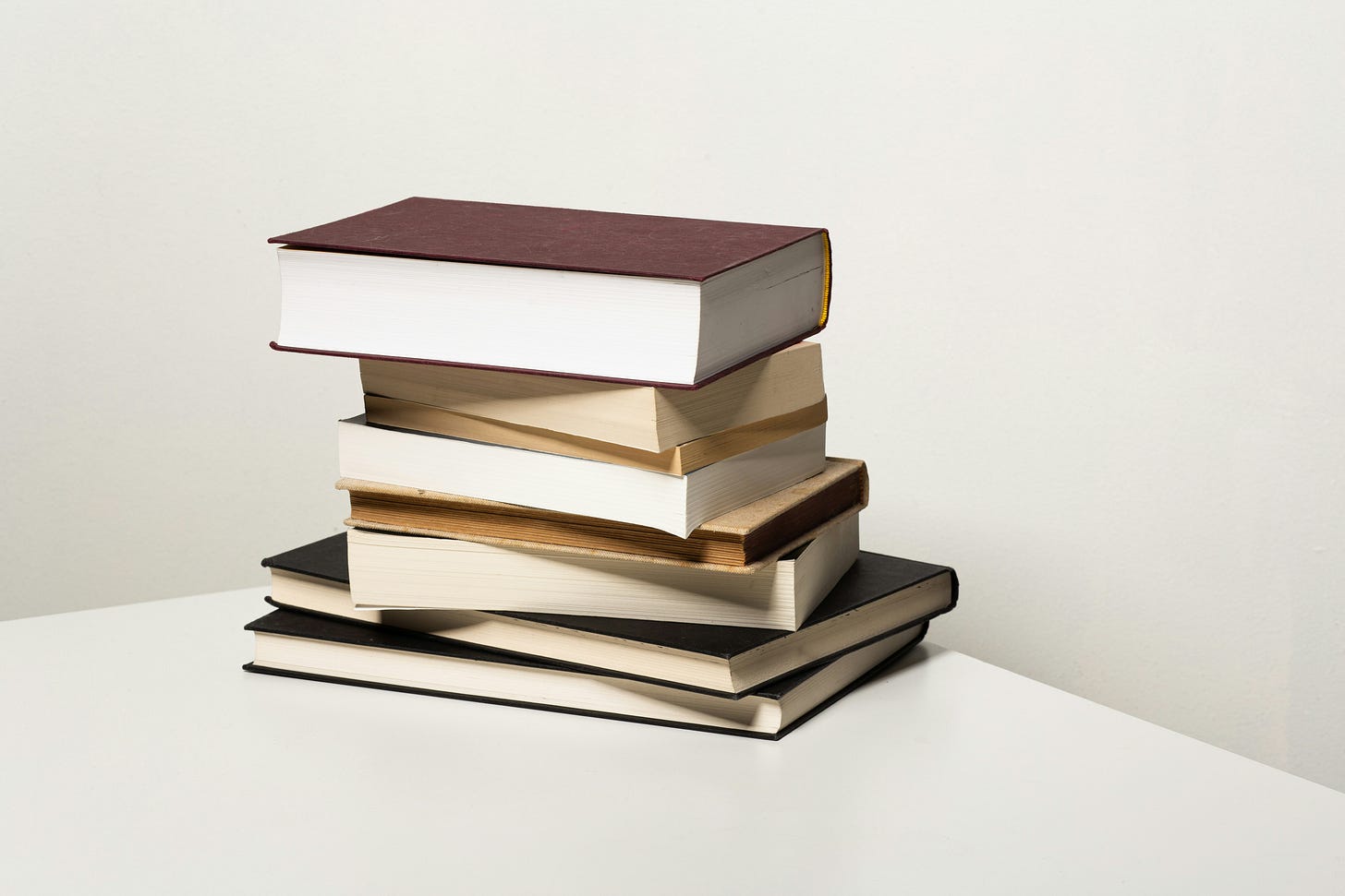 A stack of books on a white table. 
