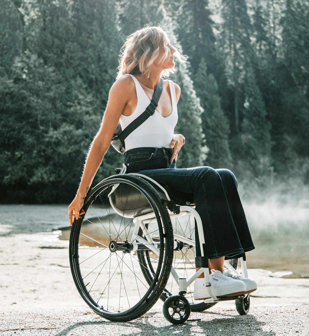 woman riding wheelchair near trees woman riding wheelchair near trees