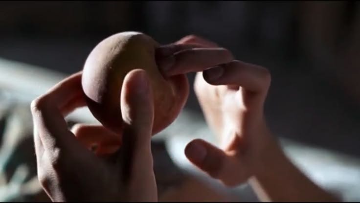 This may contain: a person holding something in their hands with one hand and the other on top of it