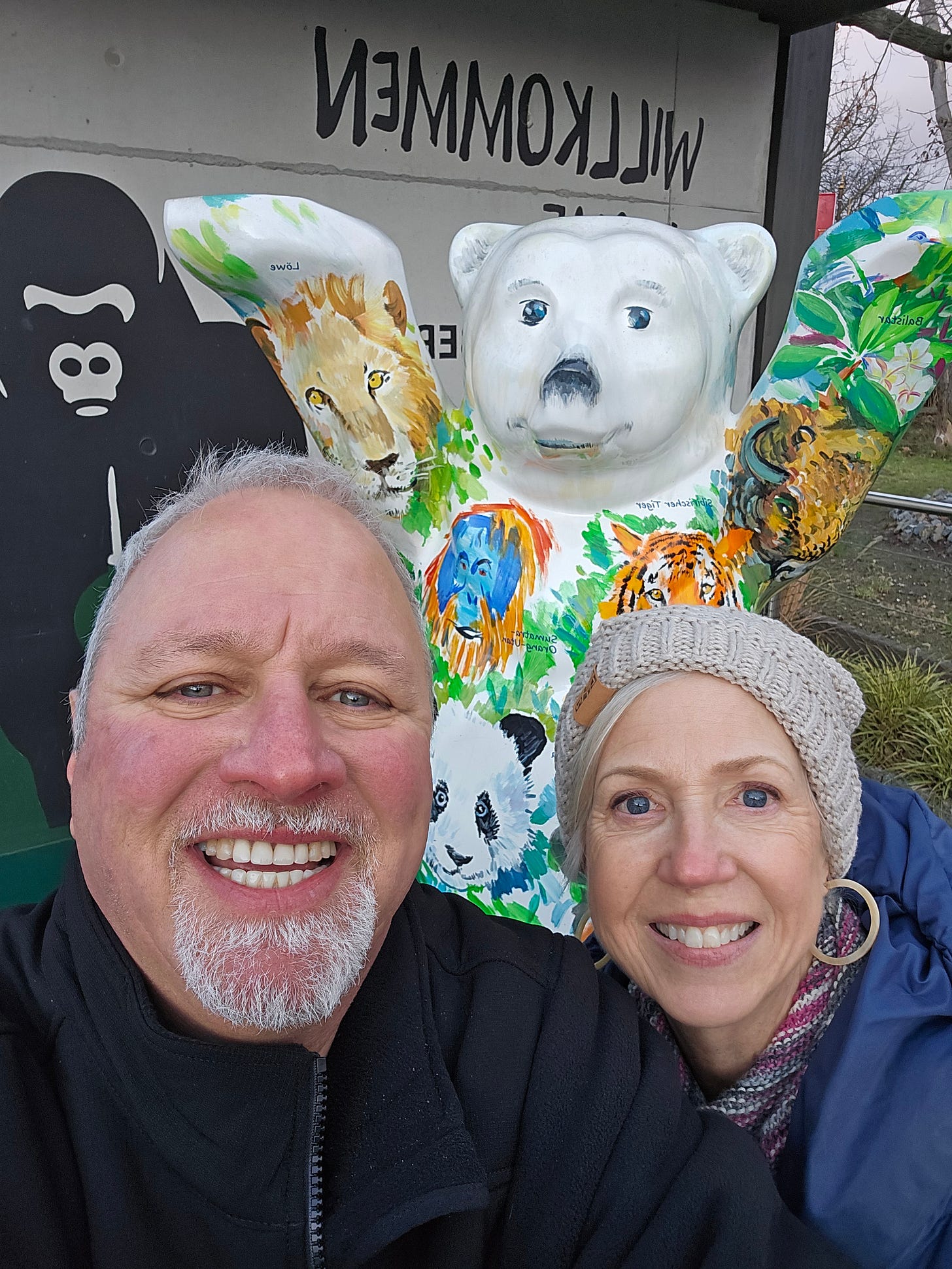 older couple standing in front of Berlin bear by the Berlin Zoo