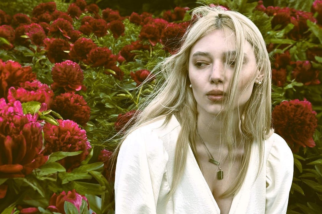 A young woman looking a little perturbed in a field of flowers A young woman looking a little perturbed in a field of flowers