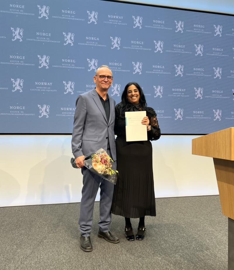The men's committee at CLaus Jervell hands over the report to Minister of Culture Lubna Jaffery
