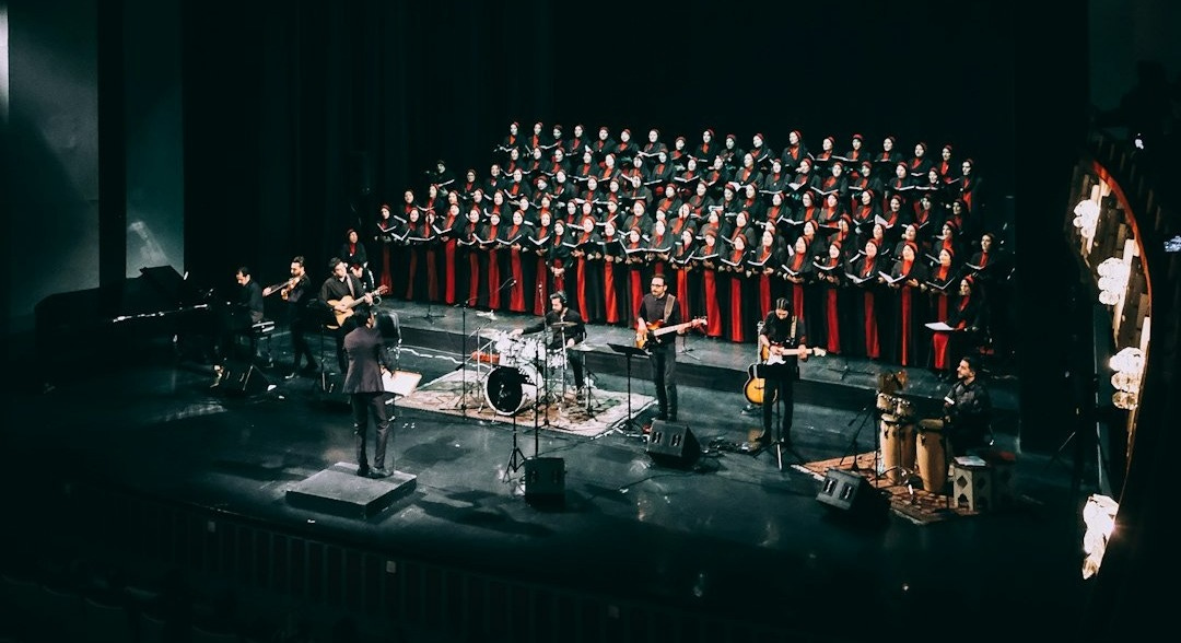 people standing on stage in front of red curtain