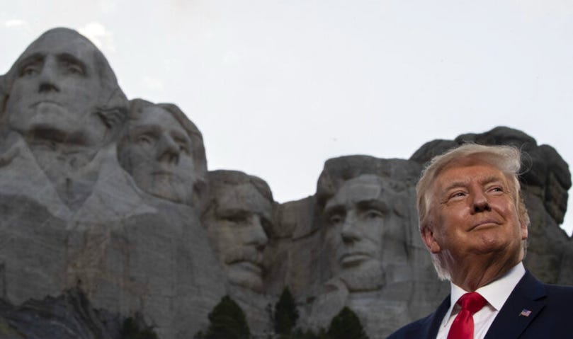 A person standing in front of a stone mountain with Mount Rushmore National Memorial in the background

Description automatically generated