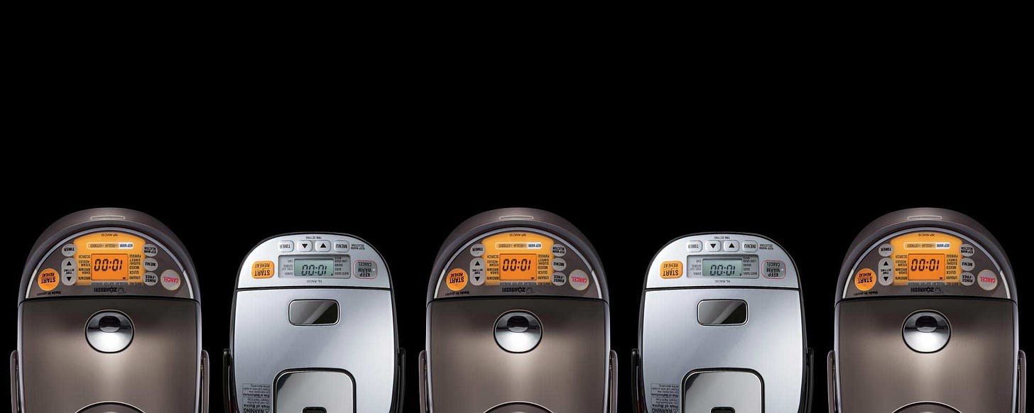 A birds-eye-view of Zojirushi rice cookers against a black background A birds-eye-view of Zojirushi rice cookers against a black background