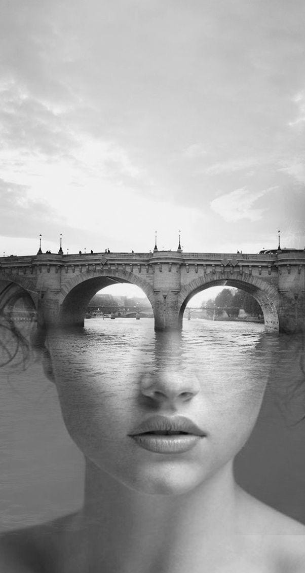 This may contain: a woman's face is reflected in the water with an old bridge behind her