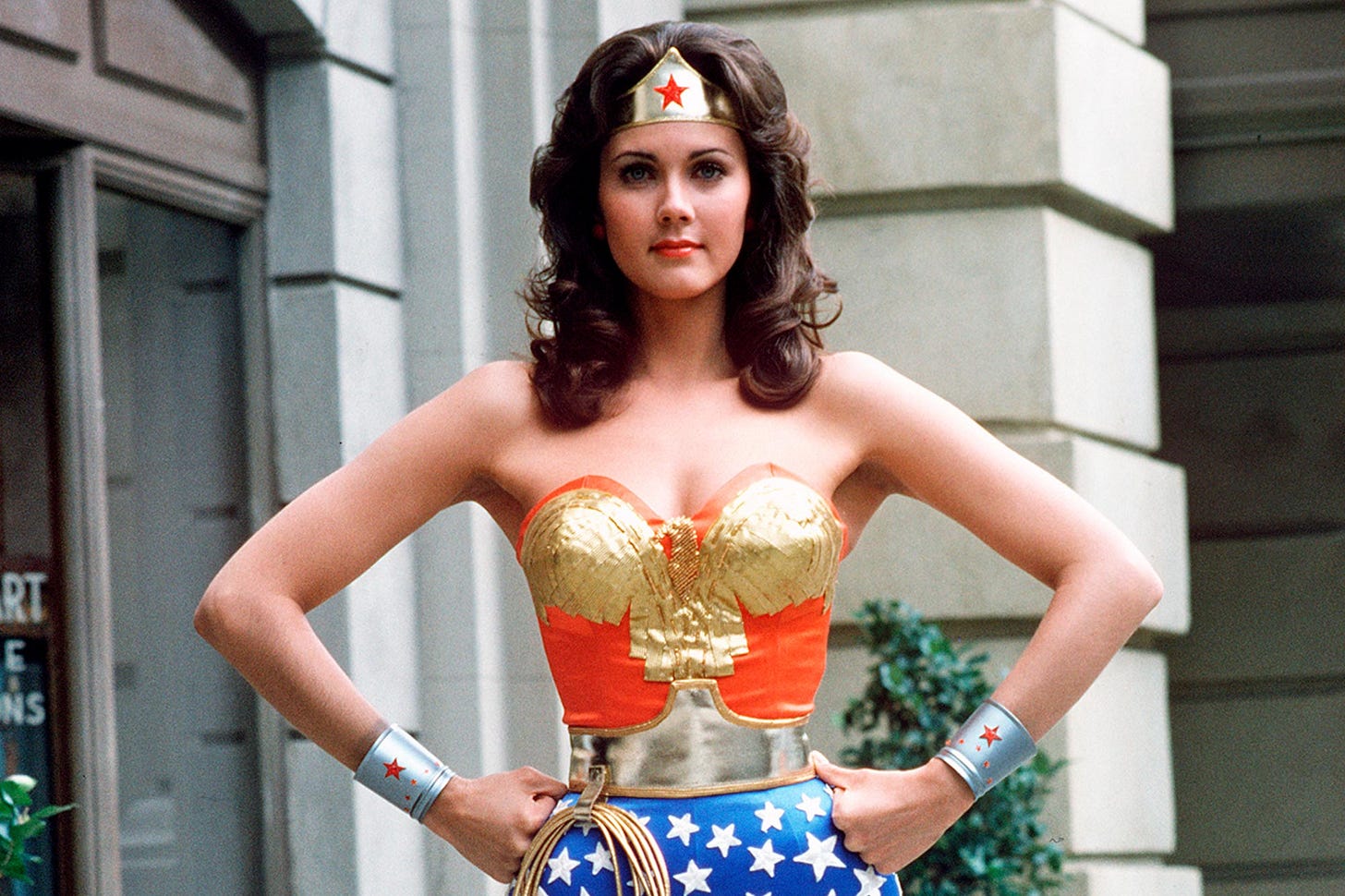 Lynda Carter as Wonder Woman, posing with her hands on her hips, looking straight ahead
