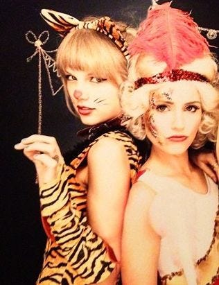 This may contain: two women dressed up as cats and zebras posing for the camera with their hands on their hips
