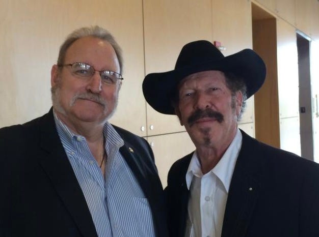 Two men standing together smiling

Description automatically generated