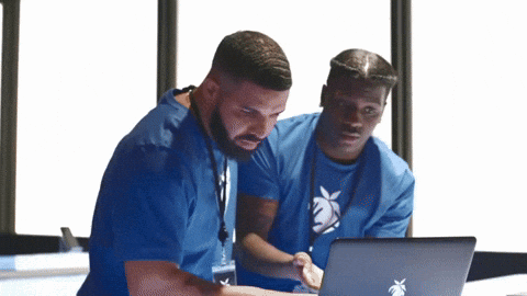 two men in blue scrubs look at a laptop computer two men in blue scrubs look at a laptop computer