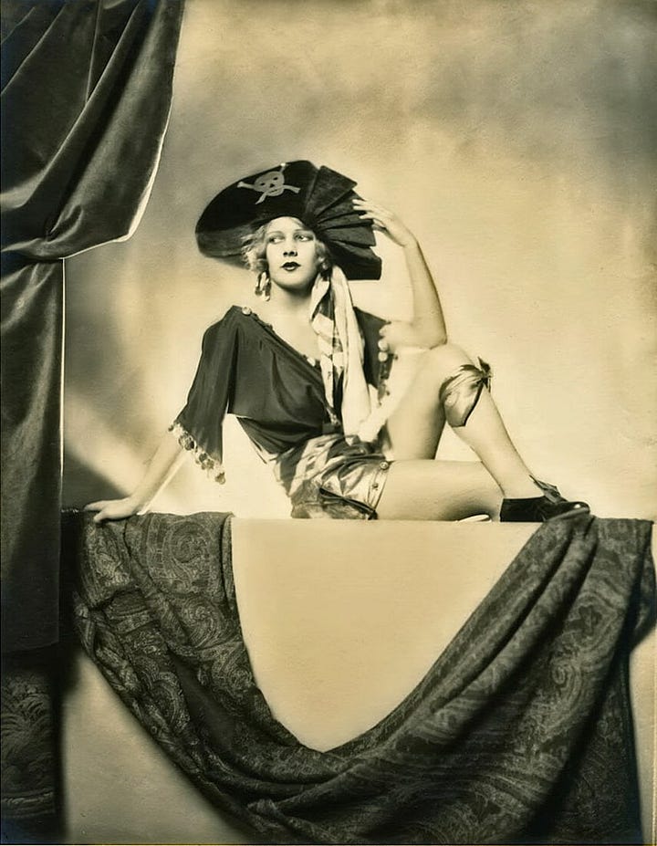 Images are two photos of Kae English. One shows her in a reclining post in a pirate costume; the other is a portrait of her holding a violin.
