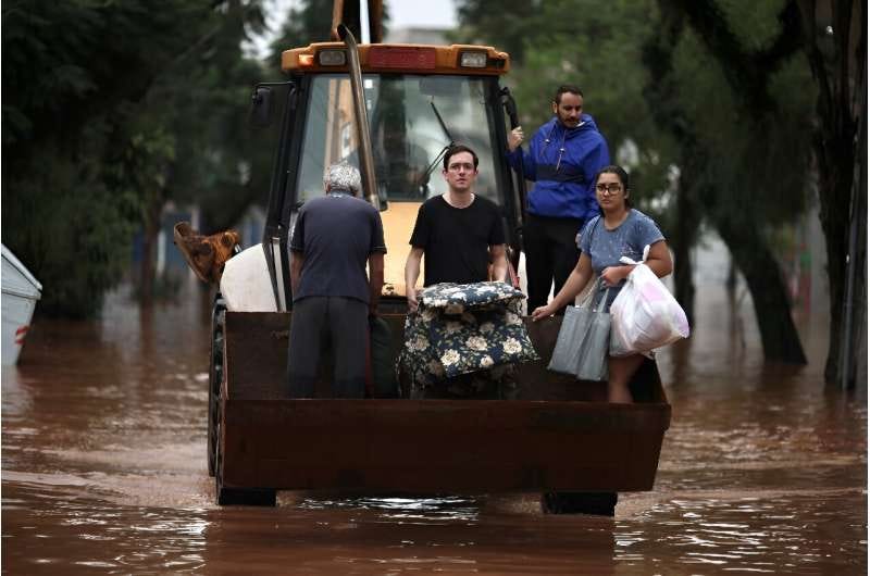 A construction vehicle carries evacuees from a flooded area of the São Geraldo neighbourhood of Porto Alegre on May 4, 2024. A construction vehicle carries evacuees from a flooded area of the São Geraldo neighbourhood of Porto Alegre on May 4, 2024.