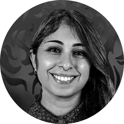 Una donna sorridente, guarda verso l'obiettivo. Ha lunghi capelli neri, lisci.