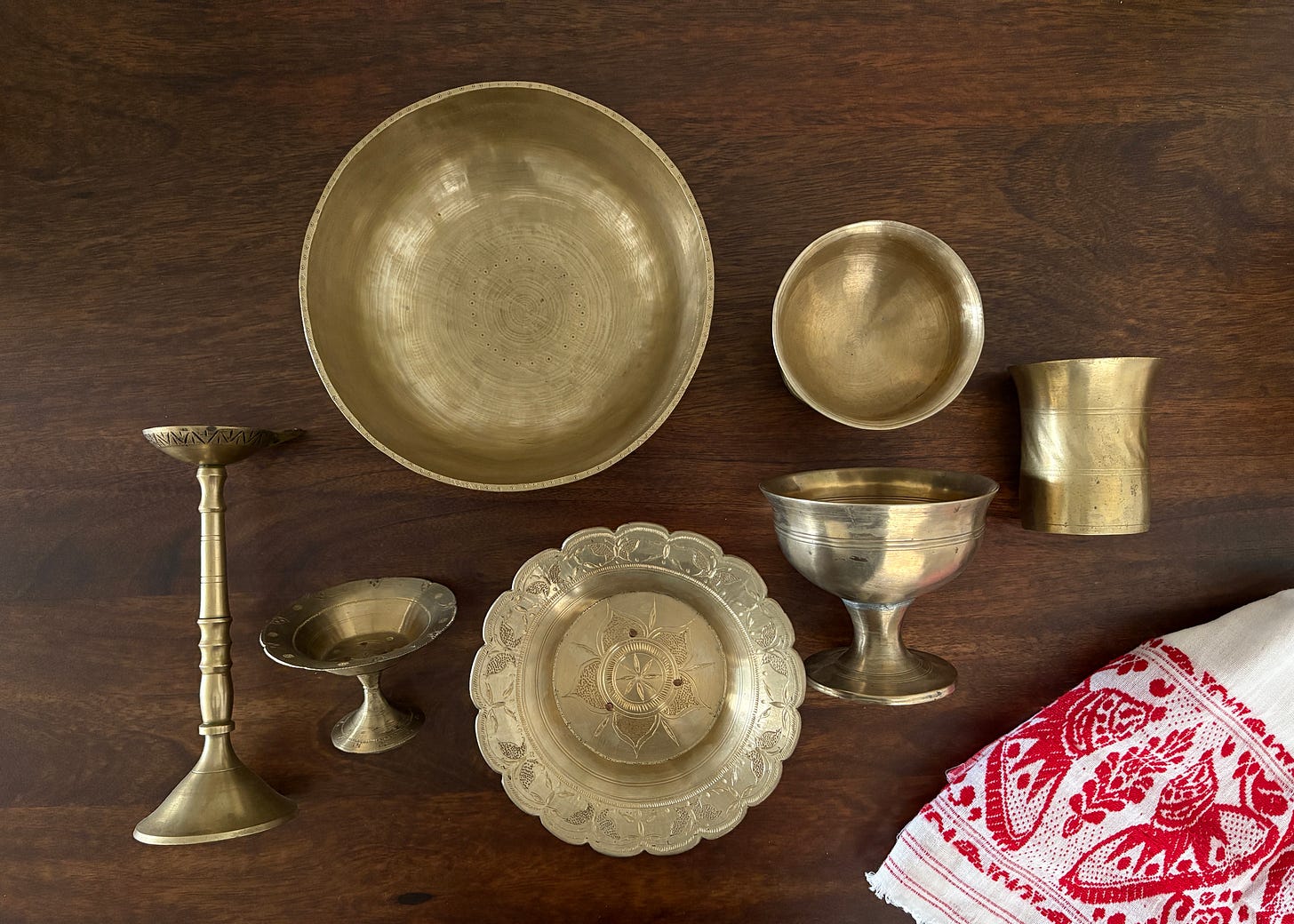 Close-up of hand-crafted bell metal utensils and ceremonial objects from Assam, showcasing traditional alloywork.