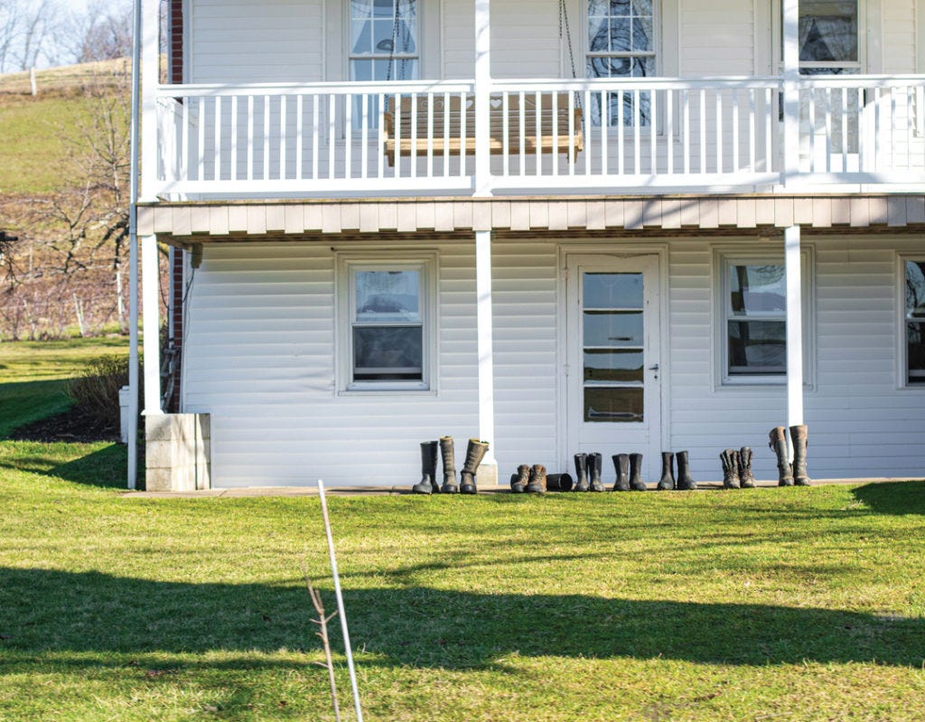Boots Lined Up in Front of an Amish House