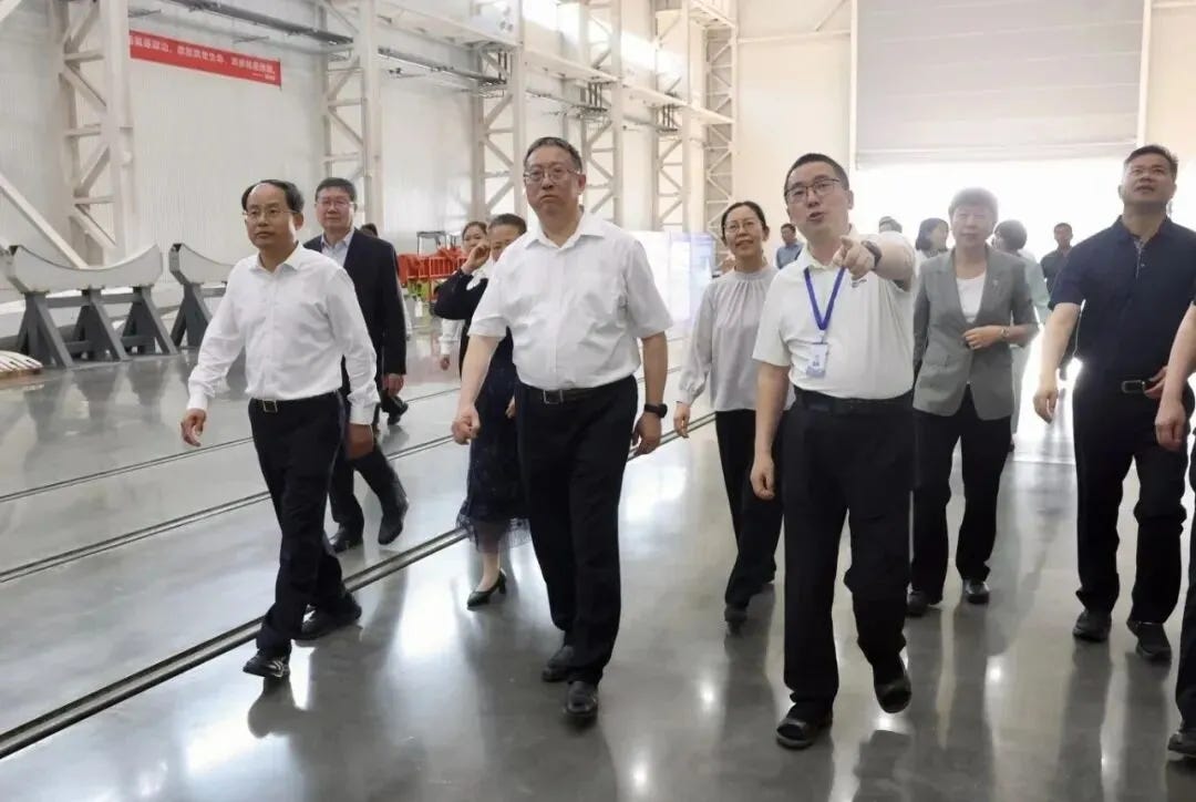 Shang Zhongde (left) and Zheng Jianbang (center) being shown around iSpace’s Wenchang launch processing and support facility in March 2026.