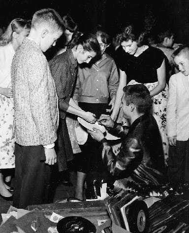 Anchorage, Alaska DJ, Ron Moore signing autographs for teen fans.