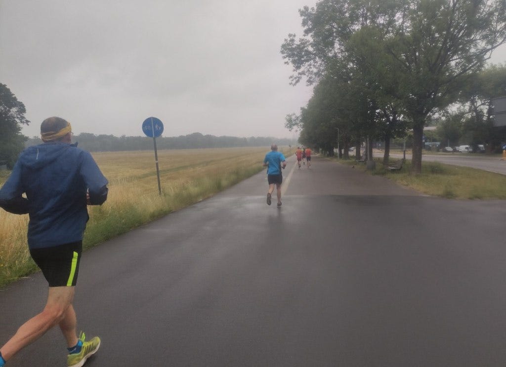 Running along a wide path in the drizzle.
