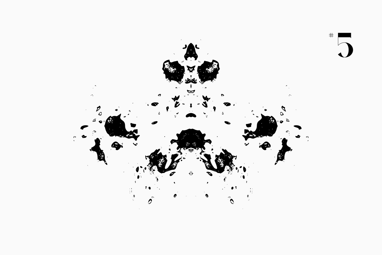 A bilateral, Rorschach-style inkblot specimen for the “In Other Words” series from The Subtext Review. The charcoal-black symmetrical splatter is centered on a cream paper background, labeled as Puzzle No. 5 in a classic serif typeface.