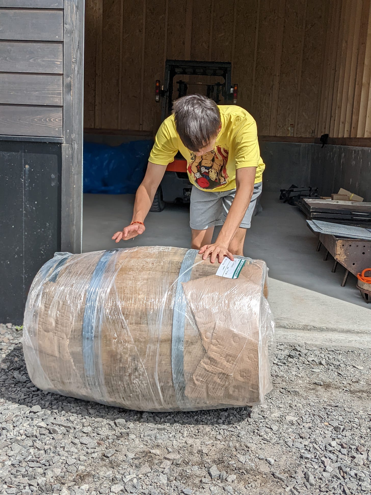 Oak barrel being rolled across warehouse and outside for first filling at Rishiri distillery