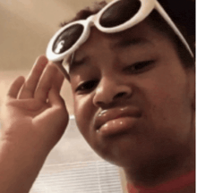 a person wearing sunglasses is making a funny face .