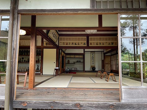 A collage of nine photos from Japan: a man in traditional kimono performing a tea ceremony; a tray of delicate kaiseki dishes with seasonal ingredients; a serene temple garden surrounded by moss and trees; a tatami room with sliding shoji doors; a mountain view with Mount Fuji in the distance; a bowl of Japanese dessert with green grapes and jelly; a Shinto wedding procession under a red umbrella; a moss-covered stone Buddha statue in a forest; and misty temple grounds framed by lush greenery.