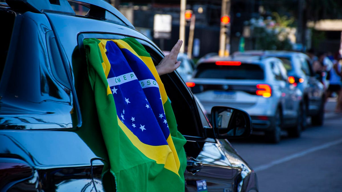 Brazilian flag in a vehicle window on a city street