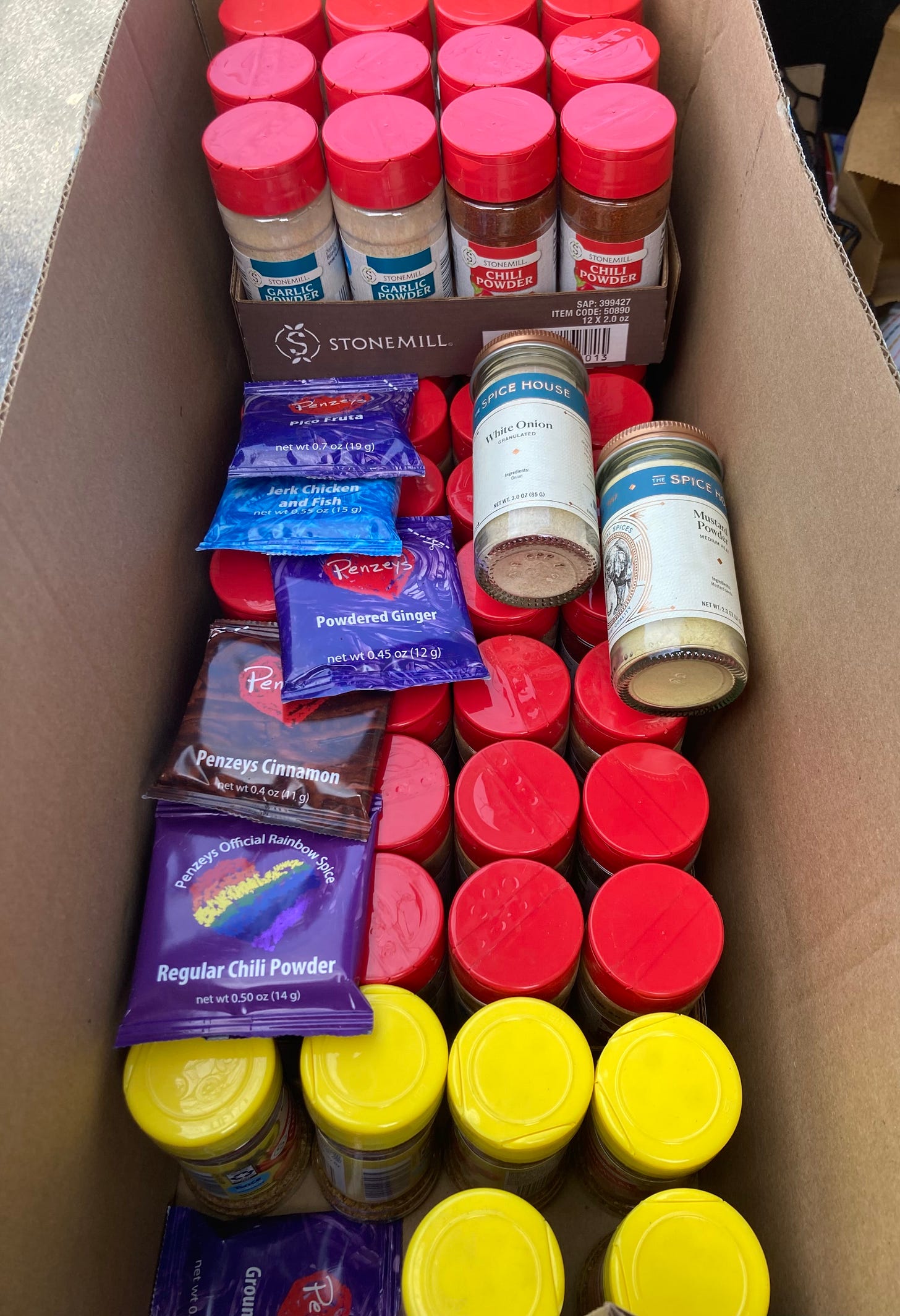A long, skinny cardboard box filled with dozens of spice jars and packets