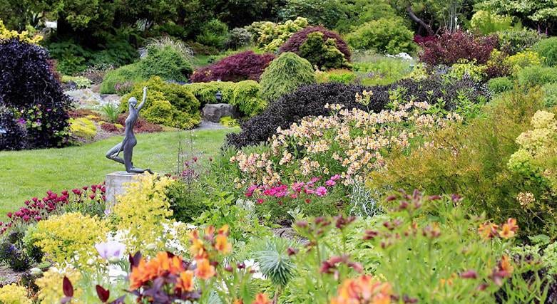A garden with a statue and flowers

AI-generated content may be incorrect.