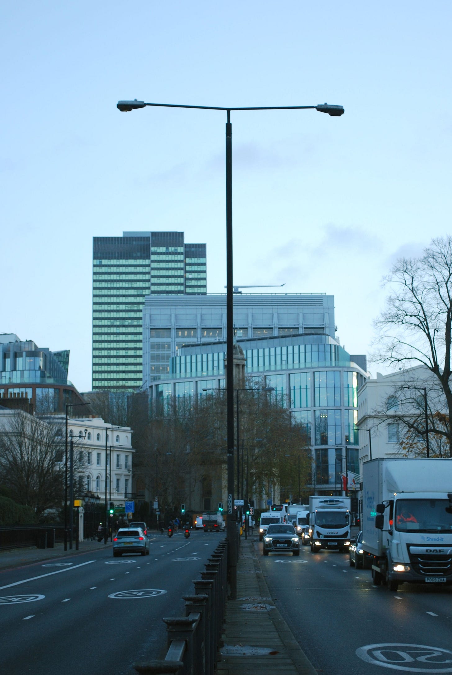 Photograph of a GLC-type street light in the centre of Marylebone Road, silhouetted against the sky, with Euston Tower in the distance