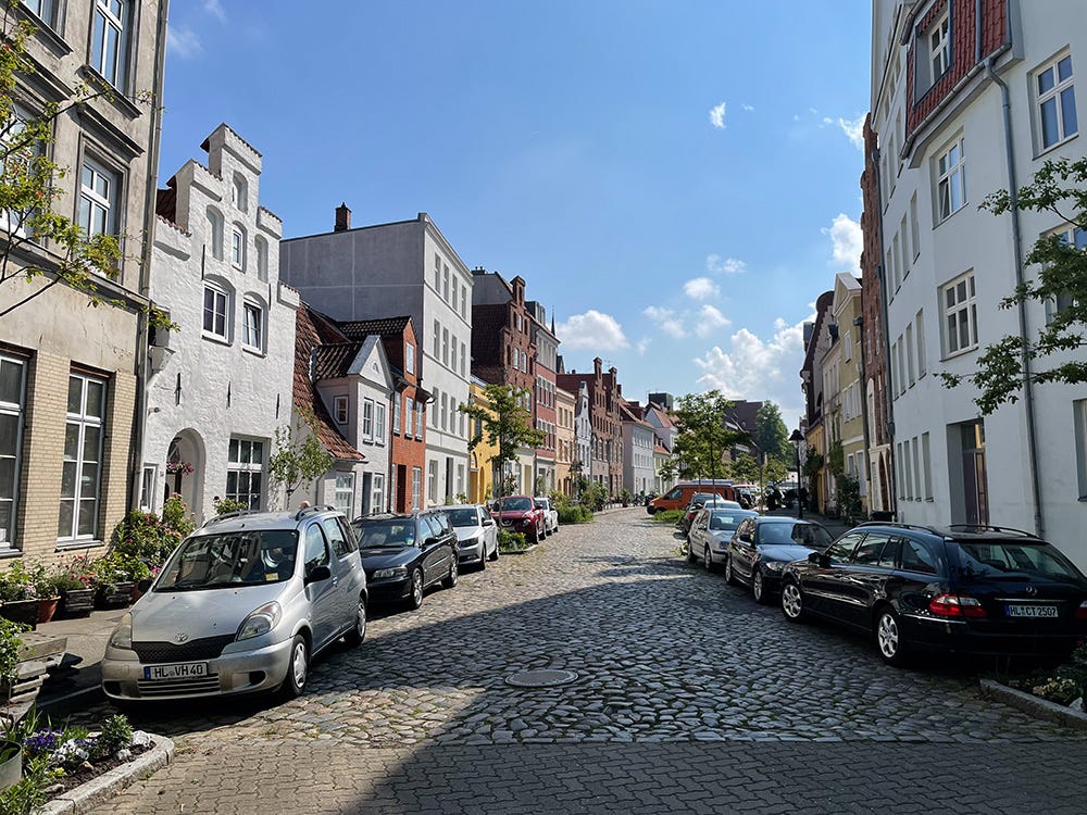A street in Lübeck, with gabled houses, cobbed road, and cars.