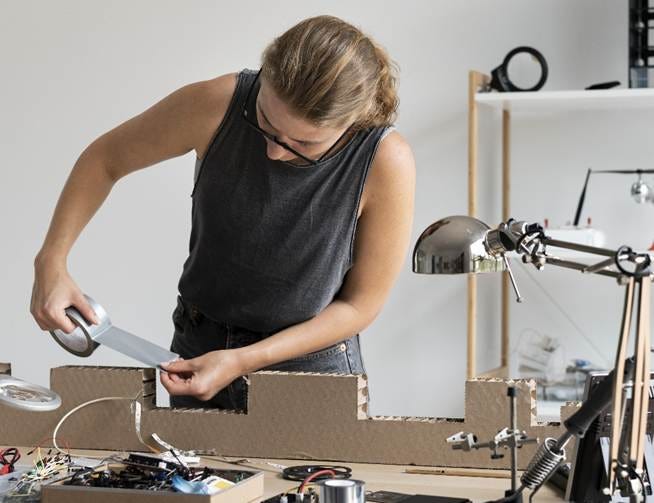 A person working on a piece of cardboard

AI-generated content may be incorrect.