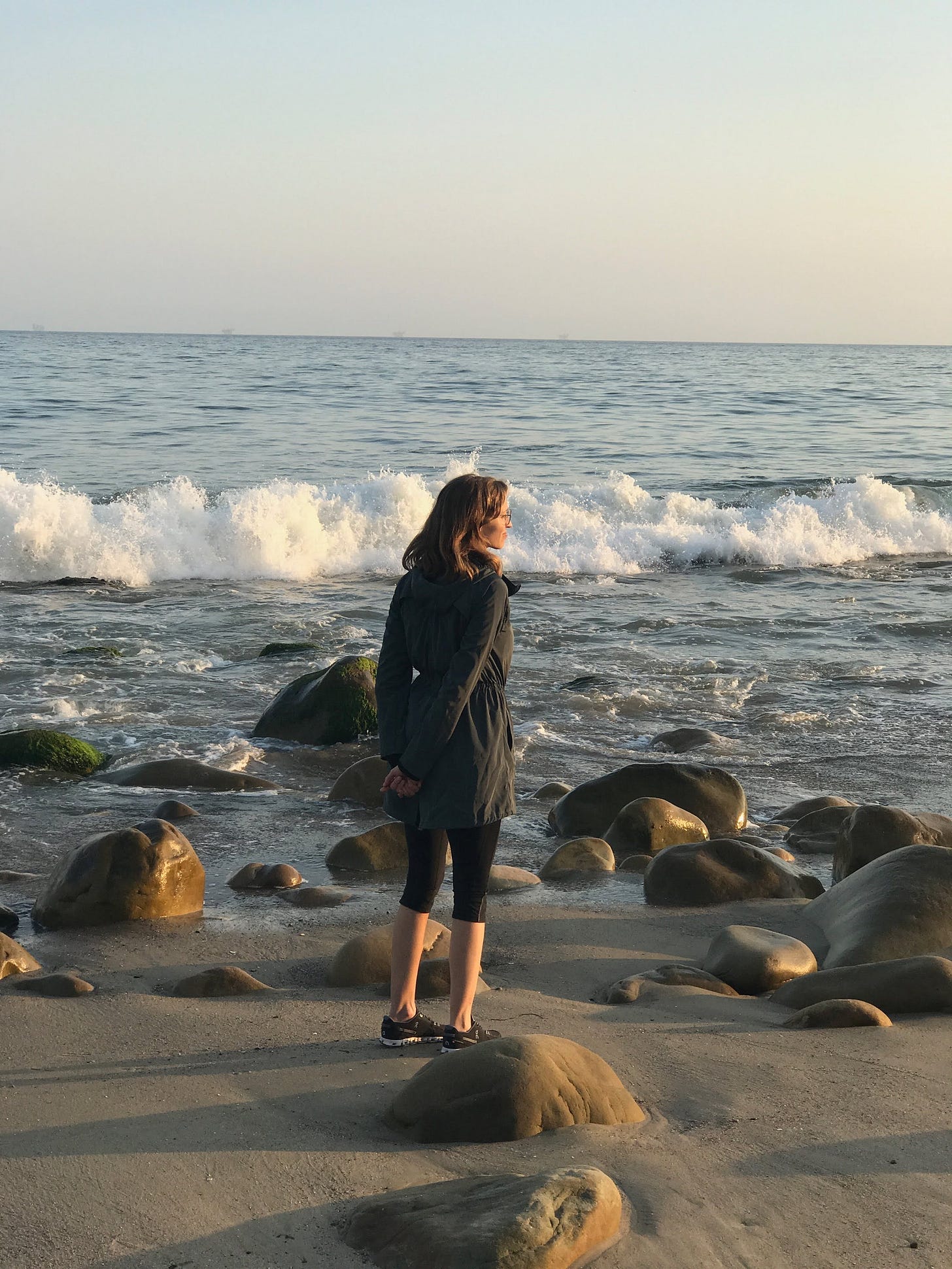 Susan staring out at the Pacific Ocean on a beach