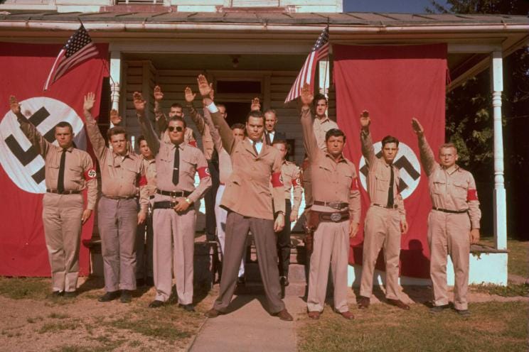 George Lincoln Rockwell (center) with his followers, including Danny Burros (far right). George Lincoln Rockwell (center) with his followers, including Danny Burros (far right).