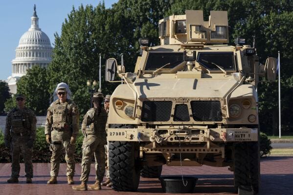 Members of the District of Columbia National Guard standing next to an MATV vehicle scan the area as they patrol outside Union Station, Monday, Sept. 1, 2025, in Washington. (AP Photo/Jose Luis Magana)