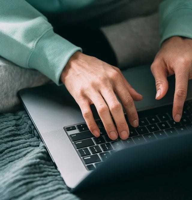 A man typing on a laptop