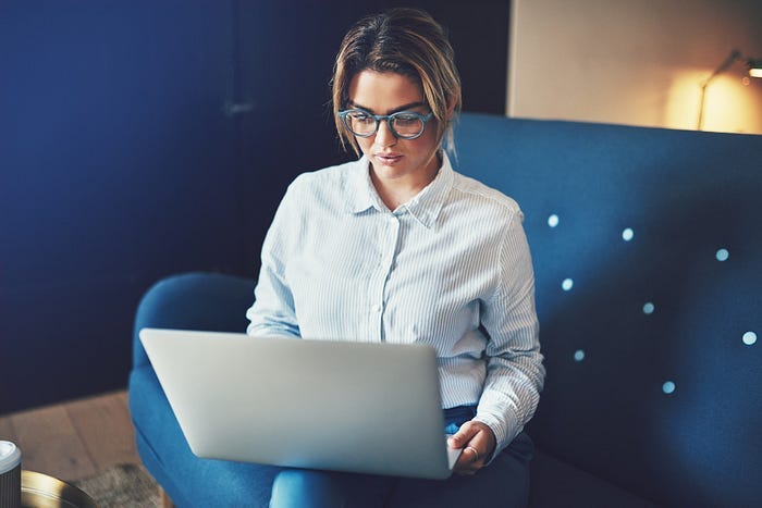 A woman working on a laptop computer. Modern trading tools have made the process of building a dividend portfolio you can trust easier than ever.