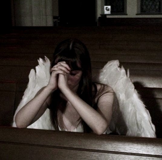 This may contain: a woman sitting in the pews of a church with her hands to her face This may contain: a woman sitting in the pews of a church with her hands to her face