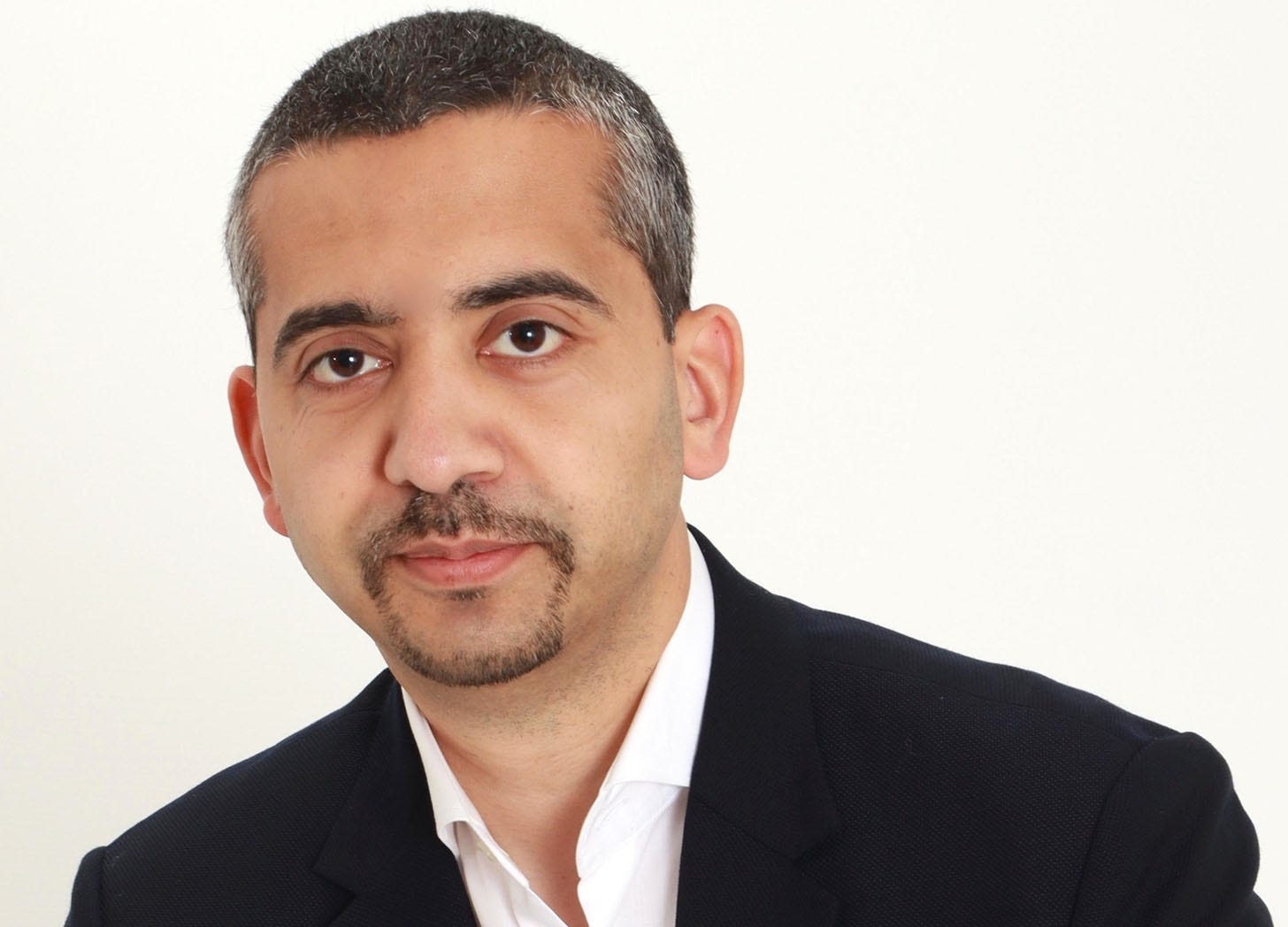 A headshot of journalist Mehdi Hasan against a white background