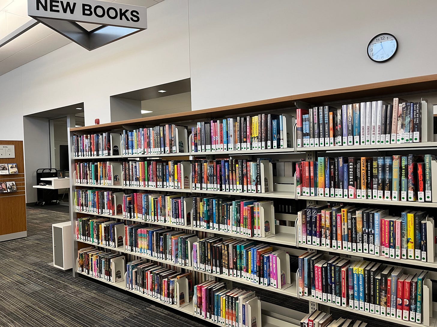 Library shelves with sign overhead that reads New Books