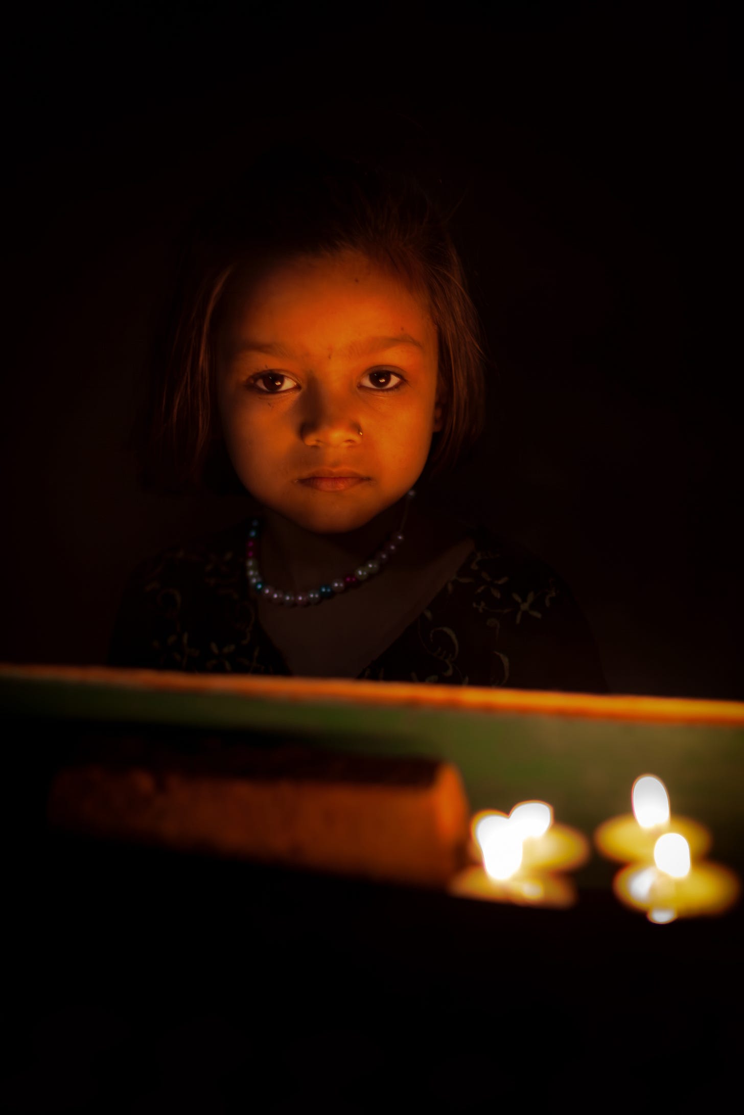 A face in the candlelight, Boudha, Nepal. 1/100, ƒ/1.2, ISO 320, 85mm