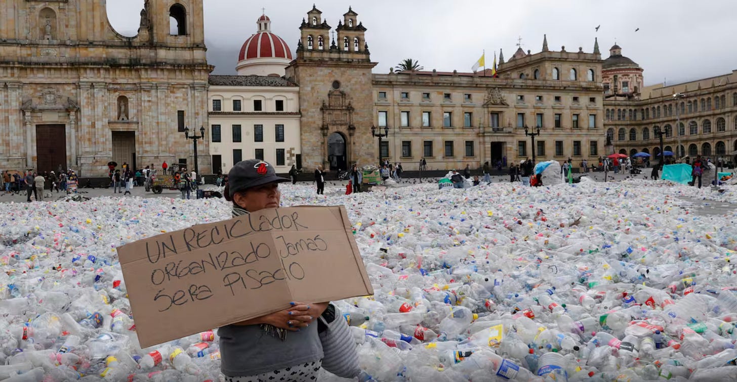 A person holds a sign during a protest on June 25, 2025 in Plaza de Bolívar in Bogotá, Colombia. Colombian recyclers scatter 12 tons of plastic bottles in protest of the low price they are being paid for collecting recyclable materials. (Credits: EFE/ Mauricio Dueñas Castañeda)