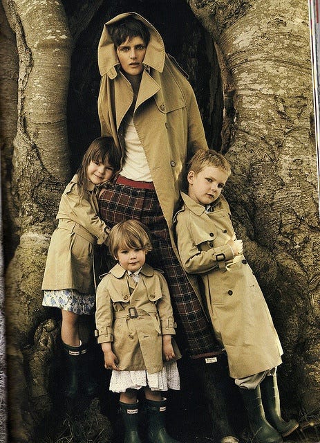 This may contain: three children in trench coats are standing next to each other